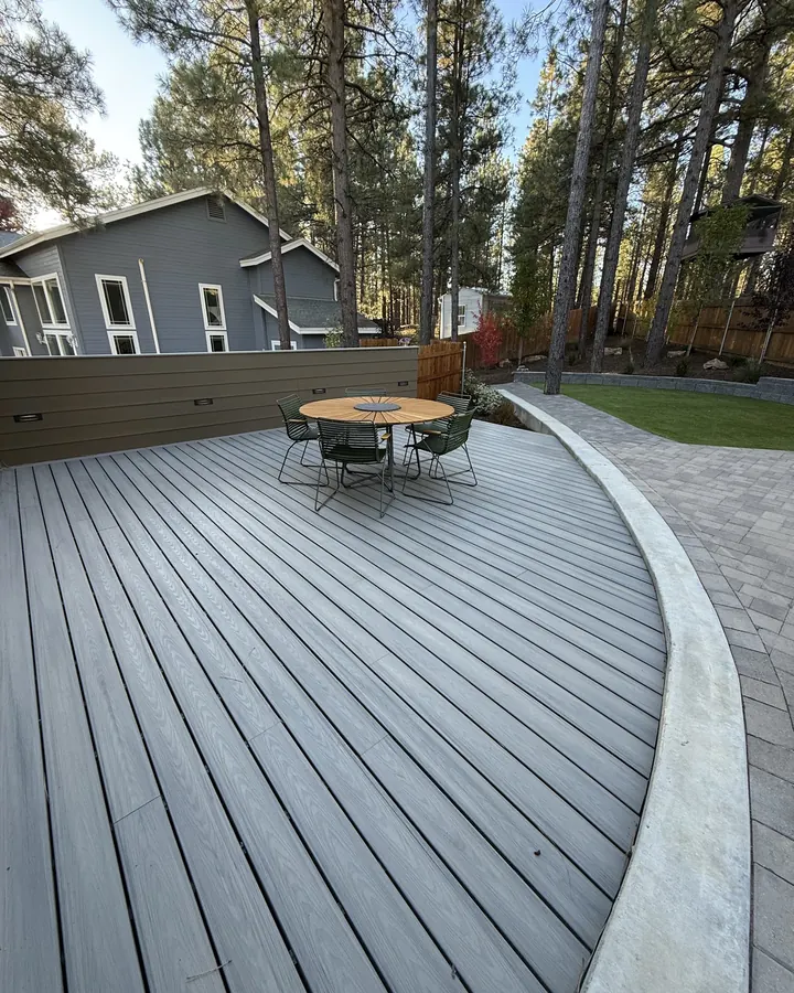 Curved composite deck meeting a paver patio