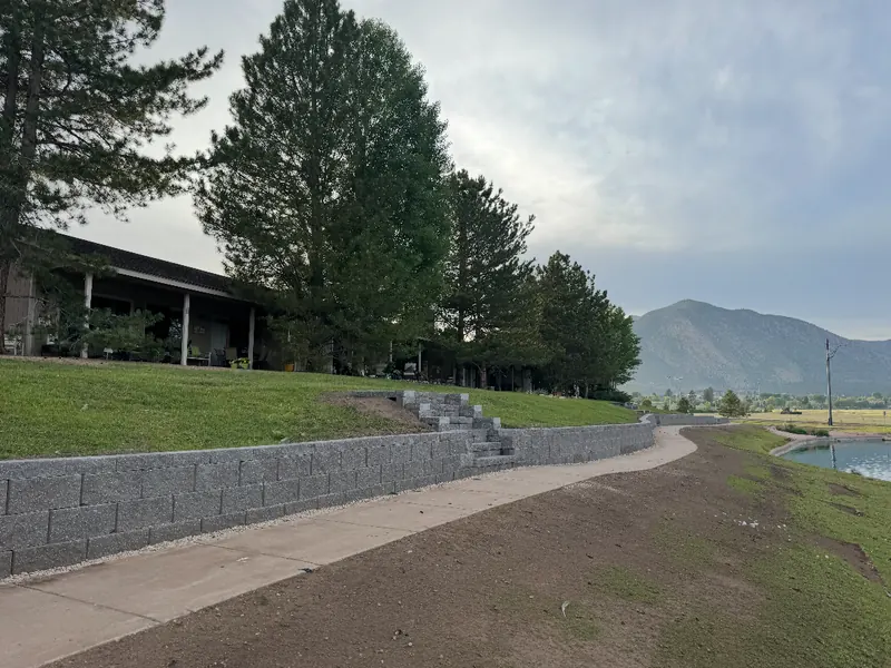 Block retaining wall and steps along a walking path